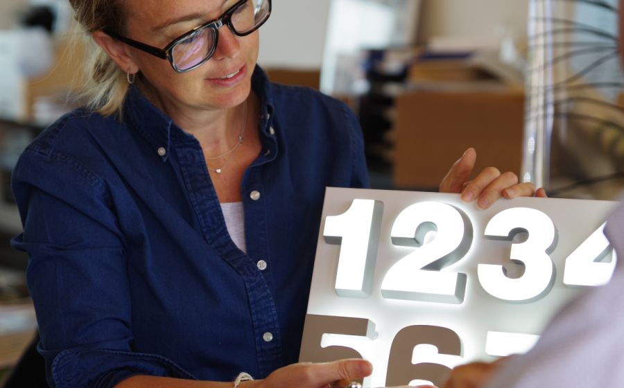 Mira präsentiert ein Werbeschild in der Manufaktur in Butzbach